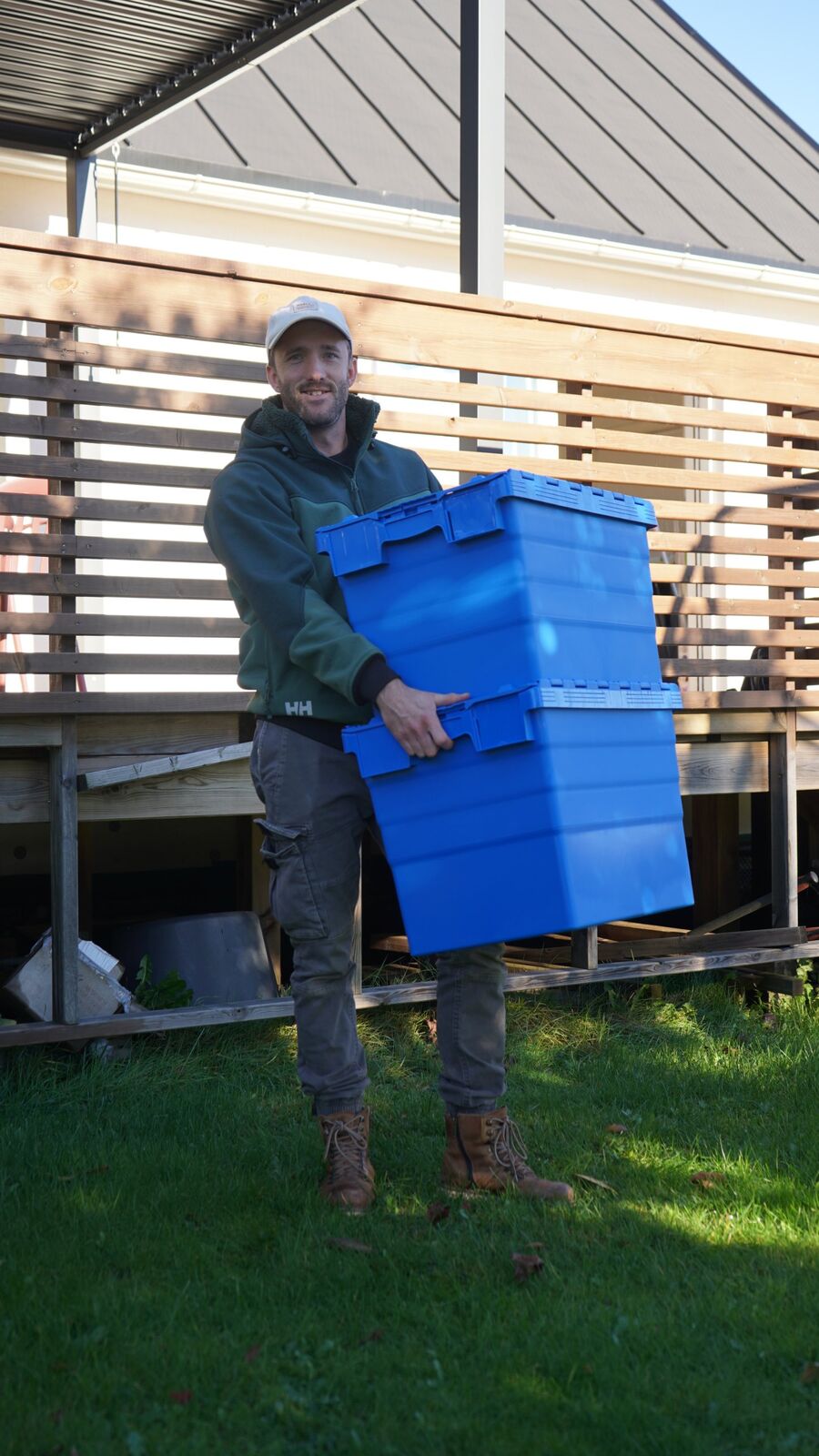 Smilende Flyttis-medarbeider med to stablede flyttekasser